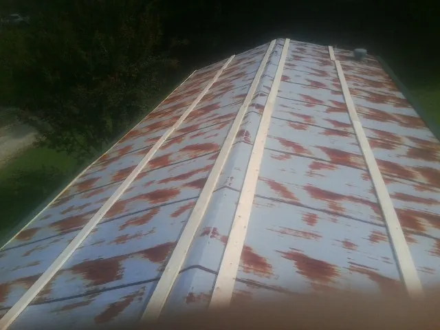 Rusted metal roof panels with new wood purlins before replacement — Storm Damage Roof Repair in Islip Terrace by Roofing Brothers