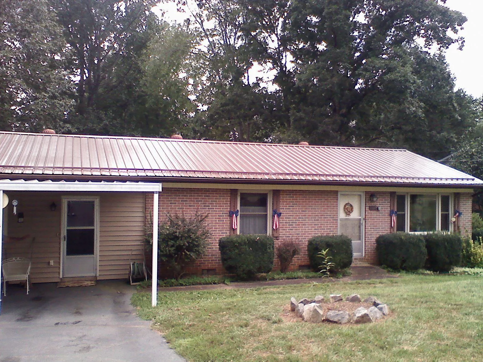 Bronze metal roof and carport on a brick ranch home — Roof Repair work by our crew in Islip Terrace